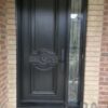 Black entry door with a decorative glass