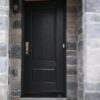 A decorative black wood-style fiberglass entry door.