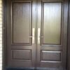 A double brown fiberglass entry door with nice handles