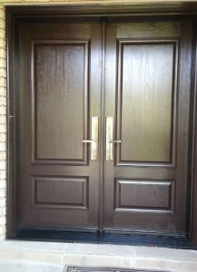 A double brown fiberglass entry door with nice handles