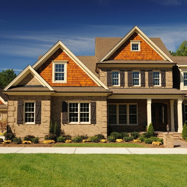 Image depicts the exterior of a home with newly installed picture windows.