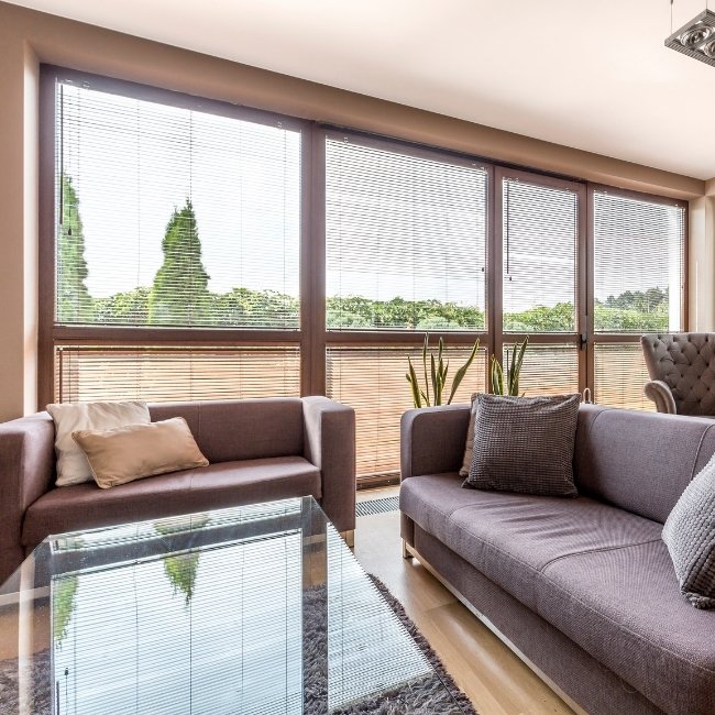 Image depicts a living room with newly installed vinyl windows.