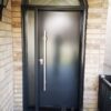 modern black steel door with pull handle and transom